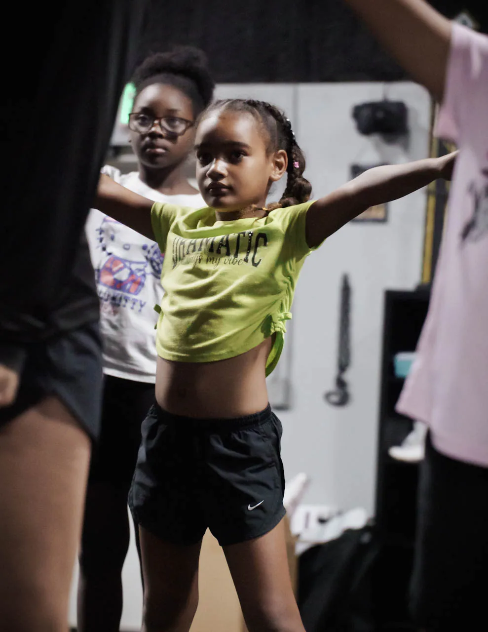 A young Category 5 athlete practicing a strong cheer motion