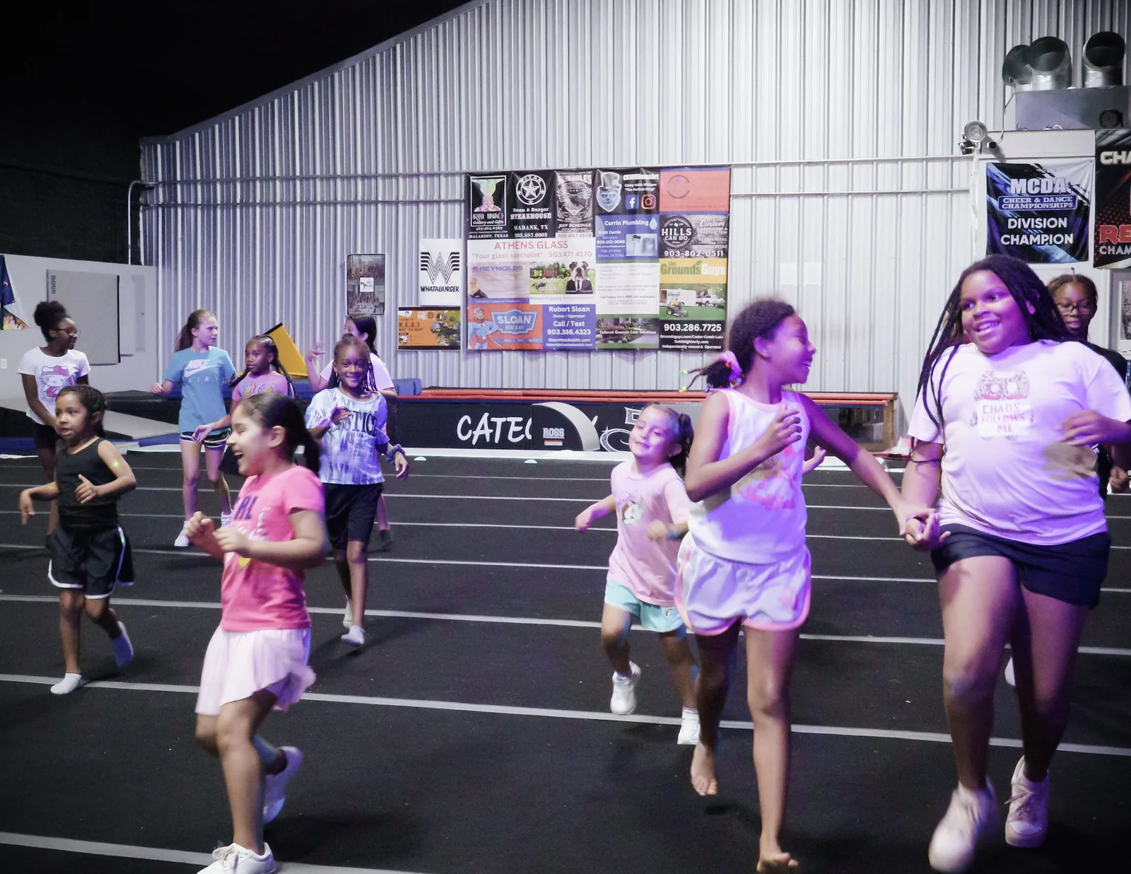 Category 5 athletes running and laughing together during camp