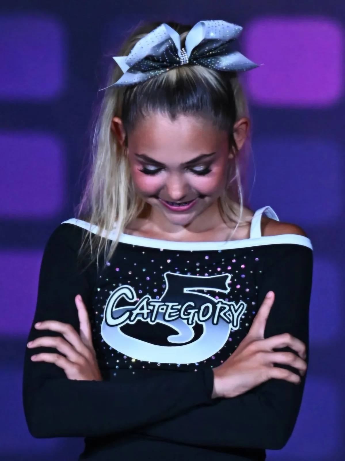 A Category 5 athlete in her competition uniform and bow
