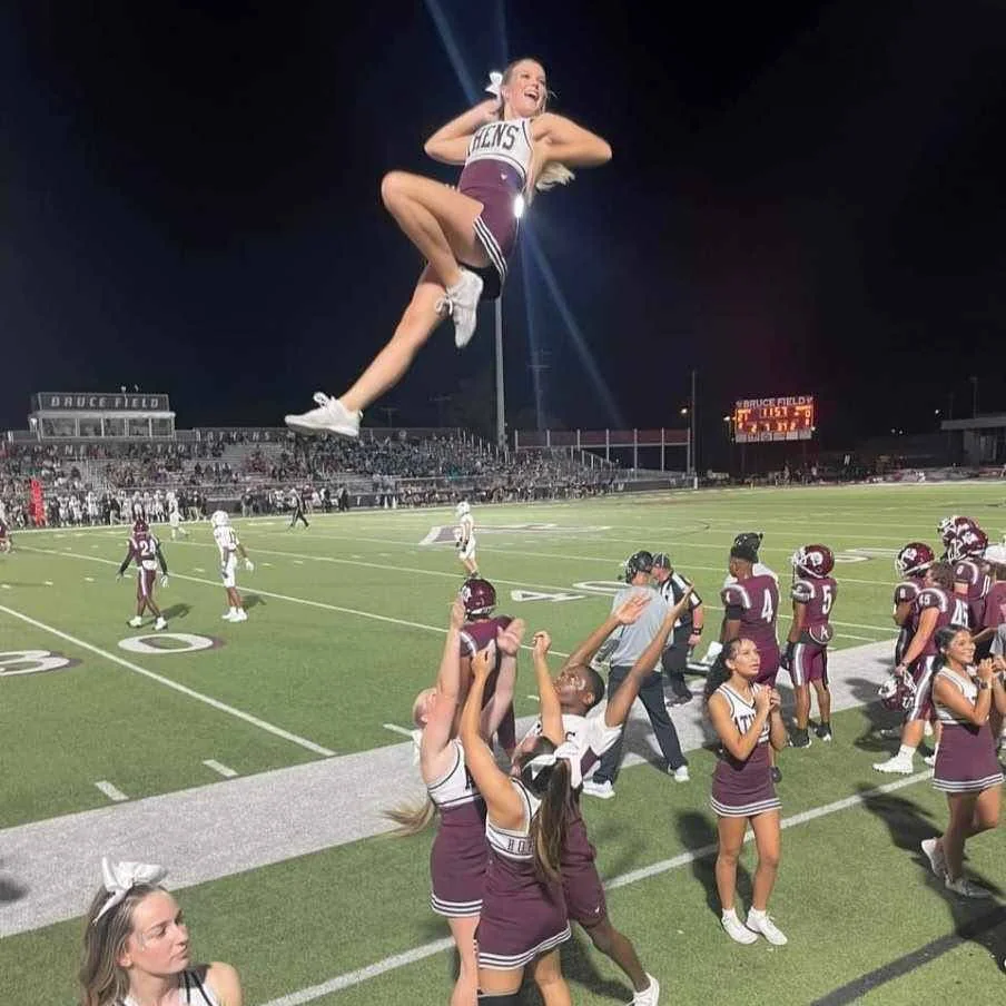 Athens school cheerleaders performing a sideline stunt